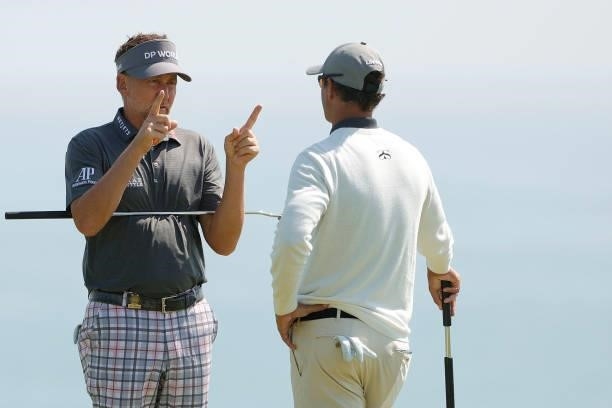 Ian Poulter of England and Adam Scott of Australia talk on the fourth green during a practice round prior to the start of the 2021 U.S. Open at...