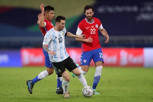 Lionel Messi of Argentina competes for the ball with Tomas Alarcon and Ben Brereton of Chile during a Group A match between Argentina and Chile at...
