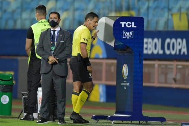 Referee Diego Mirko Haro checks the VAR to call on a possible penalty during a Group A match between Paraguay and Bolivia at Estádio Olímpico as part...