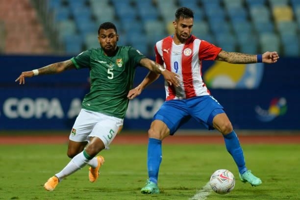 Adrian Jusino of Bolivia competes for the ball with Gabriel Avalos of Paraguay during a Group A match between Paraguay and Bolivia at Estádio...