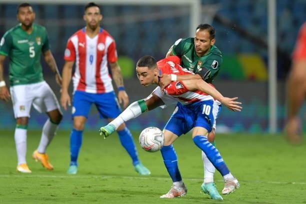 Miguel Almiron of Paraguay competes for the ball with Leonel Justiniano of Bolivia during a Group A match between Paraguay and Bolivia at Estádio...