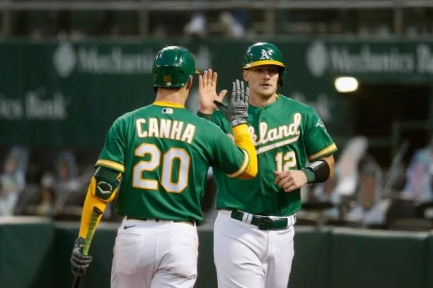 Sean Murphy of the Oakland Athletics celebrates with Mark Canha after scoring on a double by Chad Pinder in the bottom of the fifth inning against...