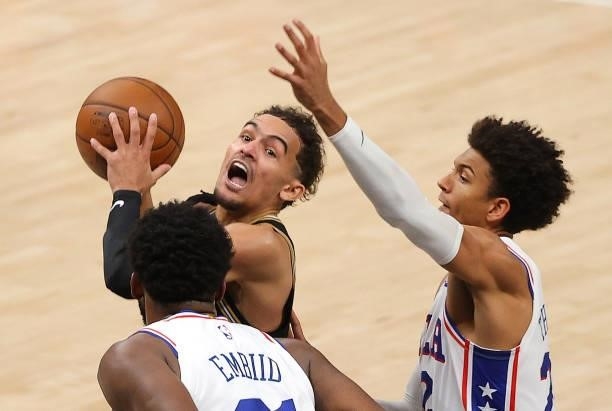 Trae Young of the Atlanta Hawks drives against Joel Embiid and Matisse Thybulle of the Philadelphia 76ers during the second half of game 4 of the...