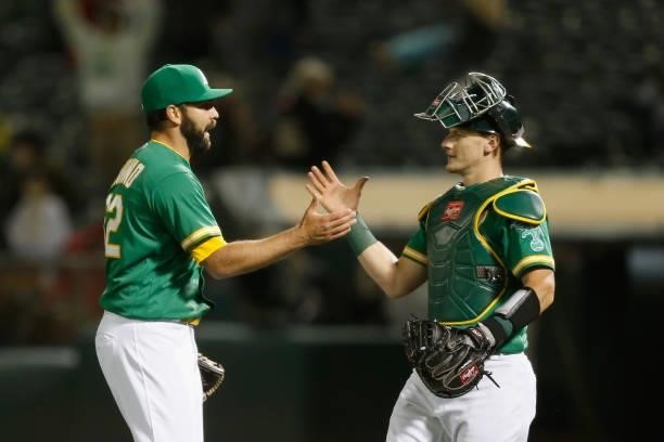 Pitcher Lou Trivino of the Oakland Athletics celebrates with catcher Sean Murphy after a win against the Los Angeles Angels at RingCentral Coliseum...