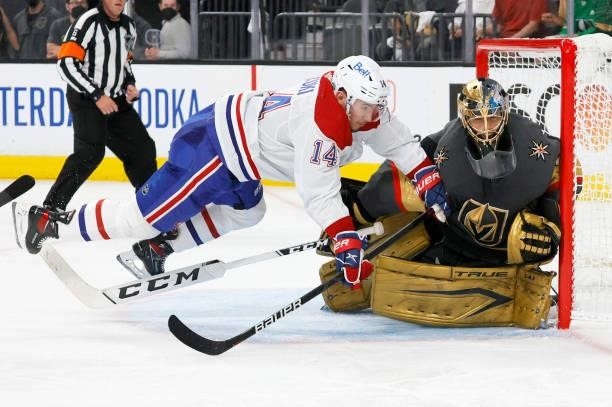 Nick Suzuki of the Montreal Canadiens trips over Marc-Andre Fleury of the Vegas Golden Knights as he defends the net in the third period in Game One...