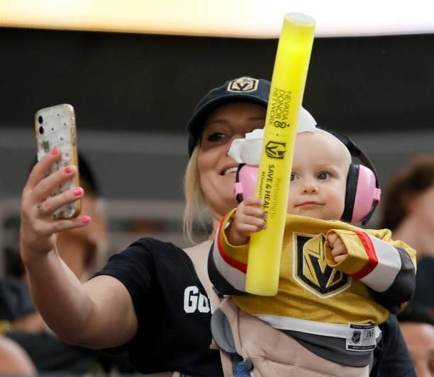 Fan takes a selfie with an infant holding a glow stick before Game One of the Stanley Cup Semifinals during the 2021 Stanley Cup Playoffs between the...