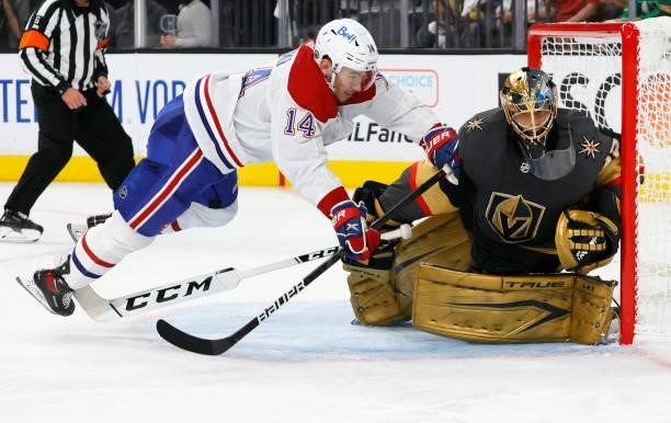 Nick Suzuki of the Montreal Canadiens trips over Marc-Andre Fleury of the Vegas Golden Knights as he defends the net in the third period in Game One...