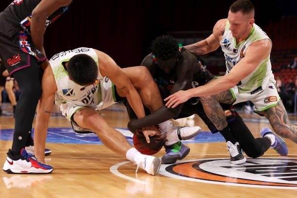 Jo Lual-Acuil of Melbourne United compete for the ball with Reuben Te Rangi and Mitch Creek of the Phoenix during game three of the NBL Semi-Final...