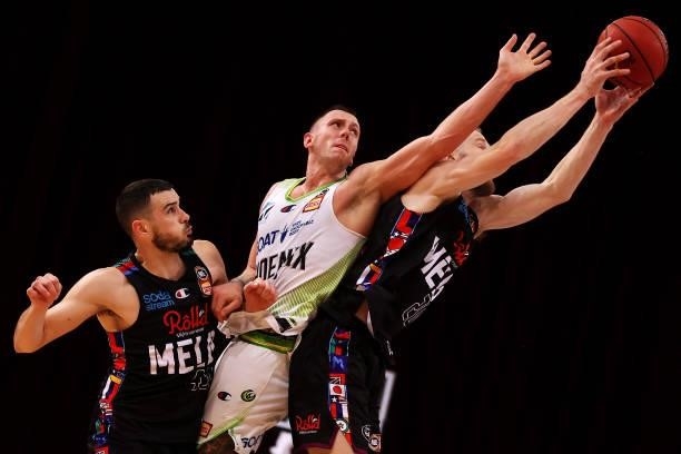 Chris Goulding and David Barlow of Melbourne United compete for the ball David Barlow compete for the ball with Mitch Creek of the Phoenix during...