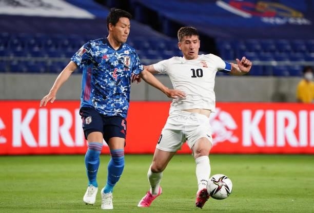Mirlan Murzaev of Kyrgyz and Gen Shoji of Japan compete for the ball during the FIFA World Cup Asian Qualifier second round Group F match between...