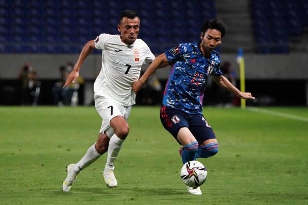Hayao Kawabe of Japan and Tursunali Rustamov of Kyrgyz compete for the ball during the FIFA World Cup Asian Qualifier second round Group F match...