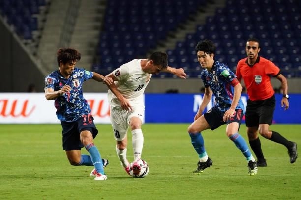 Mirlan Murzaev of Kyrgyz competes for the ball against Hidemasa Morita and Genki Haraguchi of Japan during the FIFA World Cup Asian Qualifier second...