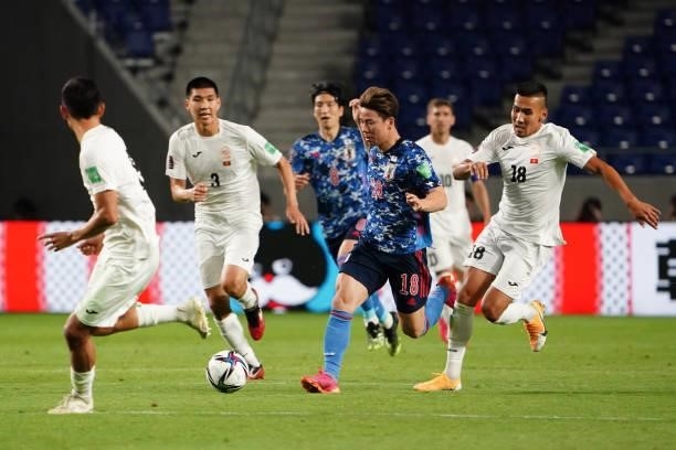 Takuma Asano of Japan and Kairat Zhyrgalbek Uulu of Kyrgyz compete for the ball during the FIFA World Cup Asian Qualifier second round Group F match...