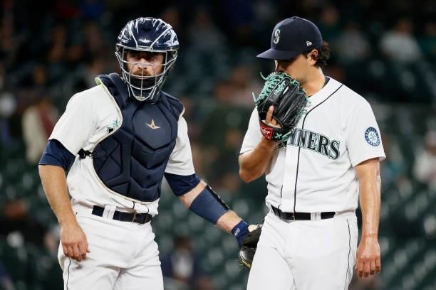 Tom Murphy and Marco Gonzales of the Seattle Mariners meet at the pitchers mound during the game against the Minnesota Twins at T-Mobile Park on June...