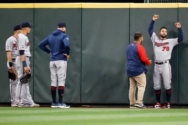 Gilberto Celestino of the Minnesota Twins is tended to after slamming into the outfield wall on an RBI triple by Dylan Moore of the Seattle Mariners...