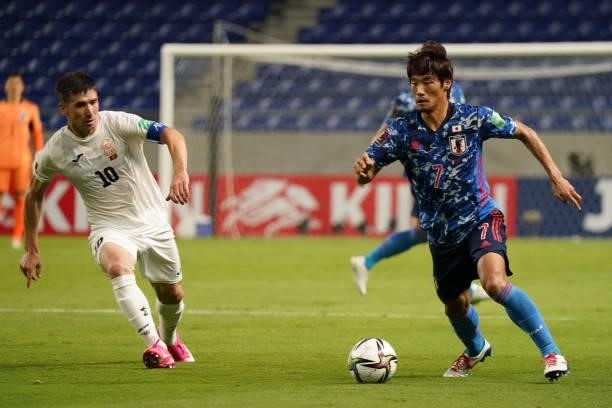 Hidemasa Morita of Japan and Mirlan Murzaev of Kyrgyz compete for the ball during the FIFA World Cup Asian Qualifier 2nd round Group F match between...