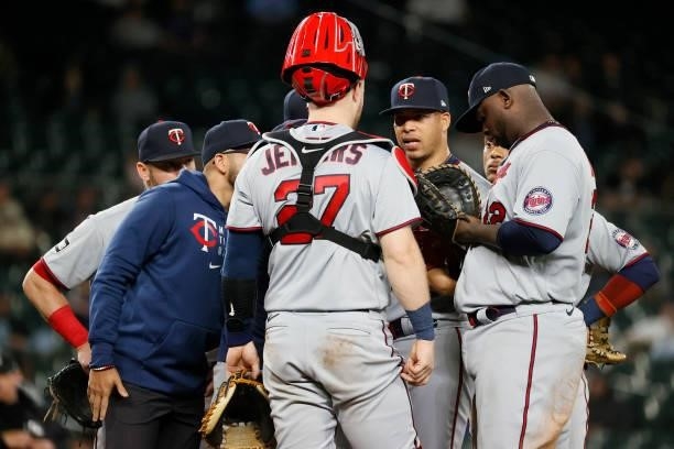 Hansel Robles of the Minnesota Twins is surrounded by his teammates during a stoppage of play against the Seattle Mariners at T-Mobile Park on June...