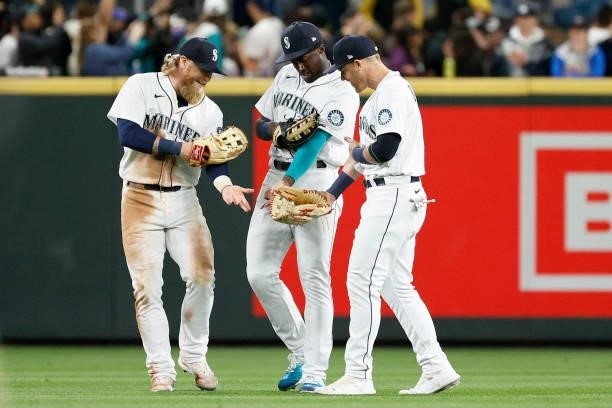 Jake Fraley, Taylor Trammell and Jake Bauers of the Seattle Mariners celebrate their 4-3 win against the Minnesota Twins at T-Mobile Park on June 14,...