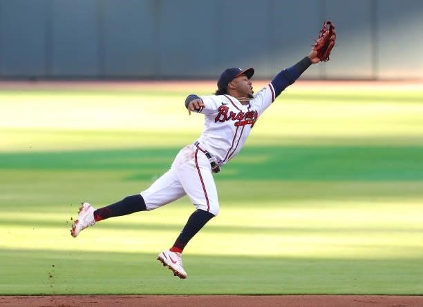 Ozzie Albies of the Atlanta Braves leaps and attempts to catch a line drive single by Enrique Hernandez of the Boston Red Sox to lead off the first...