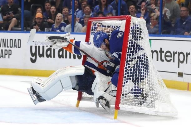 Brayden Point of the Tampa Bay Lightning collides with Semyon Varlamov of the New York Islanders in the net during the first period in Game Two of...