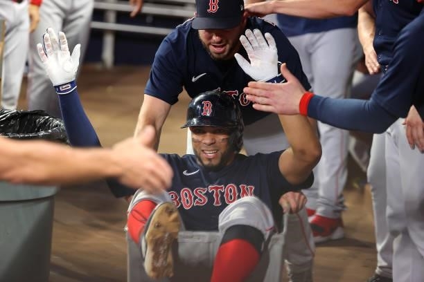 Xander Bogaerts of the Boston Red Sox celebrates as he is pushed in a clothing cart after a solo homer in the fifth inning against the Atlanta Braves...