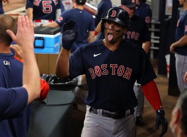 Rafael Devers of the Boston Red Sox celebrates scoring on a RBI single by Hunter Renfroe in the fifth inning against the Atlanta Braves at Truist...