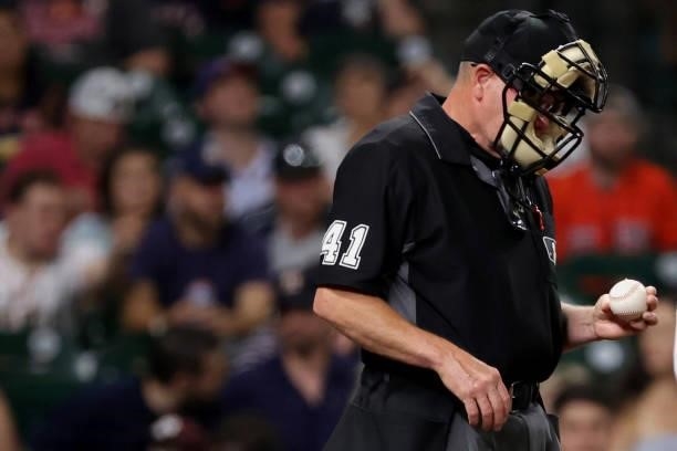 Umpire Jerry Meals checks a ball during the fourth inning between the Houston Astros and the Texas Rangers at Minute Maid Park on June 15, 2021 in...