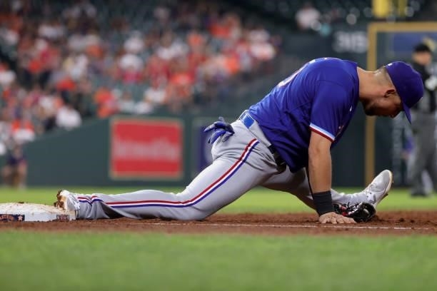 Nate Lowe of the Texas Rangers lays out to attempt an out at first on runner Jose Altuve of the Houston Astros during the third inning at Minute Maid...