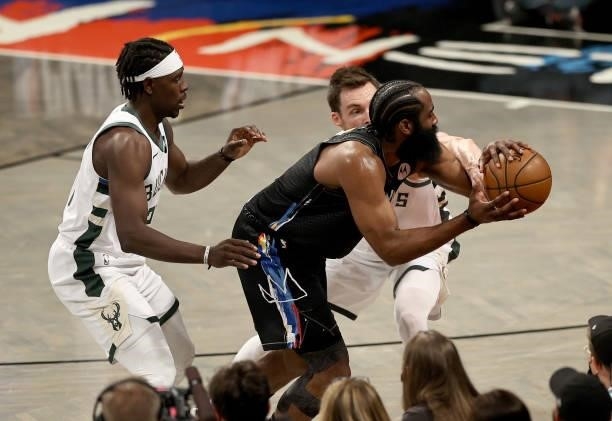 James Harden of the Brooklyn Nets is pressured by Jrue Holiday and Pat Connaughton of the Milwaukee Bucks in the first half during game 5 of the...