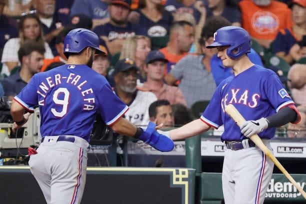 Isiah Kiner-Falefa of the Texas Rangers high fives Nate Lowe after scoring during the fifth inning against the Houston Astros at Minute Maid Park on...