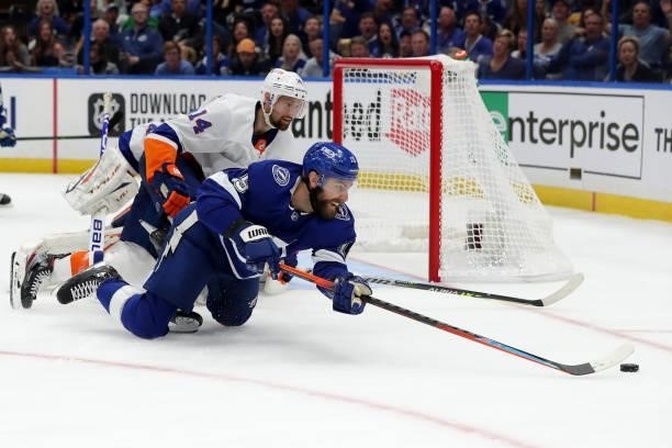 Barclay Goodrow of the Tampa Bay Lightning dives for the puck against Travis Zajac of the New York Islanders during the third period in Game Two of...