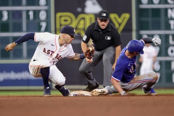 Umpire Jansen Visconti calls Nick Solak of the Texas Rangers safe after stealing second ahead of Carlos Correa of the Houston Astros during the...