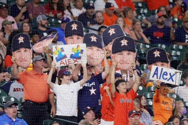 Fans hold up signs for Alex Bregman of the Houston Astros during the eighth inning against the Texas Rangers at Minute Maid Park on June 15, 2021 in...
