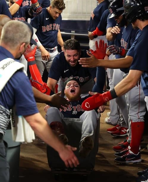 Alex Verdugo of the Boston Red Sox celebrates as he is pushed in a clothing cart after hitting a three-run homer in the eighth inning to break up the...