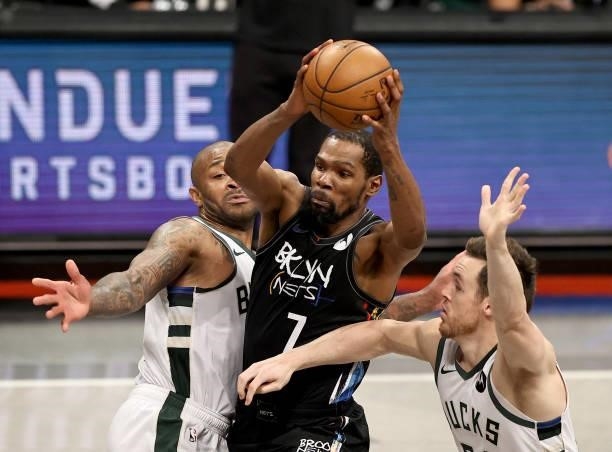 Kevin Durant of the Brooklyn Nets heads for the net as P.J. Tucker and Pat Connaughton of the Milwaukee Bucks defend during game 5 of the Eastern...