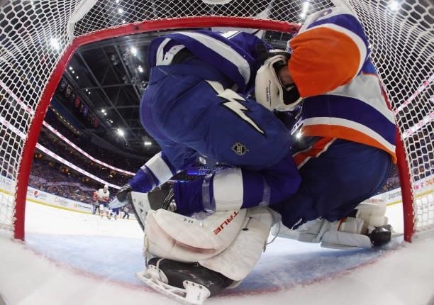 Brayden Point of the Tampa Bay Lightning falls into Semyon Varlamov of the New York Islanders during the first period in Game Two of the Stanley Cup...