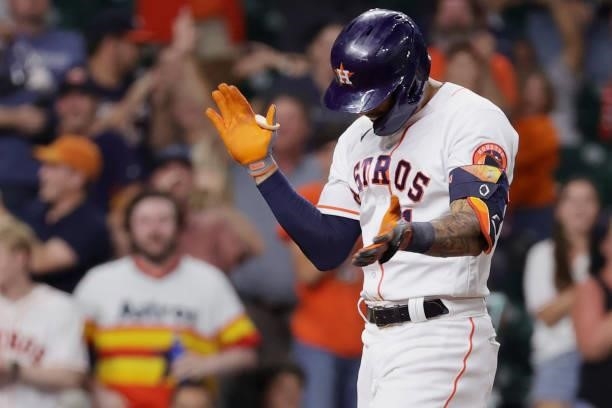 Carlos Correa of the Houston Astros celebrates after hitting a solo home run during the ninth inning to force extra innings against the Texas Rangers...