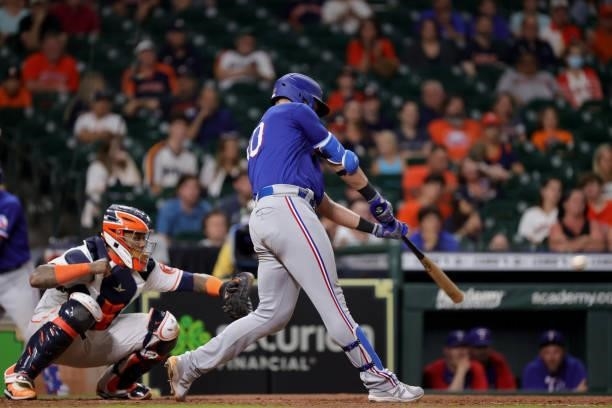 Nate Lowe of the Texas Rangers hits an RBI single during the tenth inning against the Houston Astros at Minute Maid Park on June 15, 2021 in Houston,...