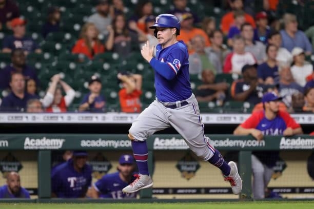 Brock Holt of the Texas Rangers scores on a single hit by Nate Lowe during the tenth inning against the Houston Astros at Minute Maid Park on June...