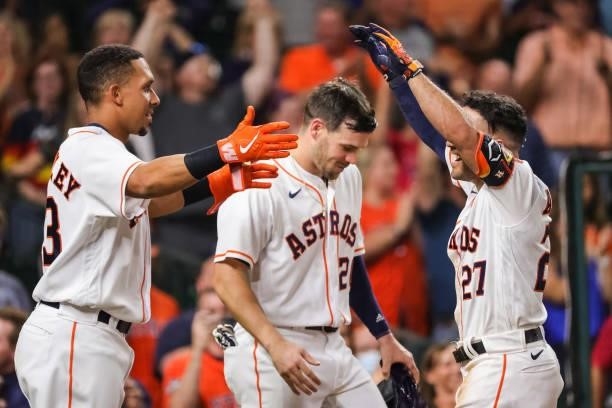 Jose Altuve of the Houston Astros hugs Michael Brantley after hitting a grand slam to defeat the Texas Rangers during the tenth inning 6-3 at Minute...