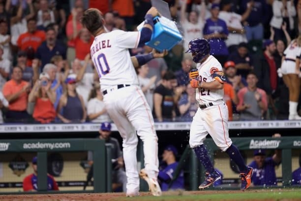 Yuli Gurriel throws gatorade on Jose Altuve of the Houston Astros after hitting a grand slam to defeat the Texas Rangers during the tenth inning by a...