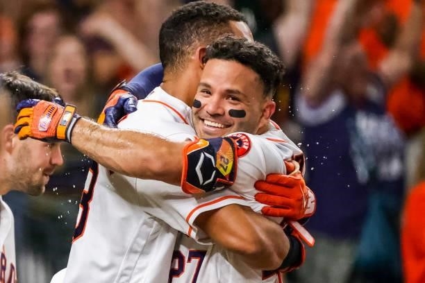 Jose Altuve of the Houston Astros hugs Michael Brantley after hitting a grand slam to defeat the Texas Rangers during the tenth inning by a score of...