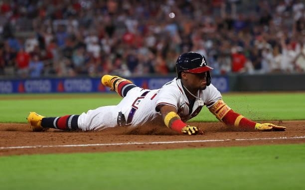 Ronald Acuna Jr. #13 of the Atlanta Braves dives safely into third base as he advances on a two-RBI double in the fourth inning against the Boston...