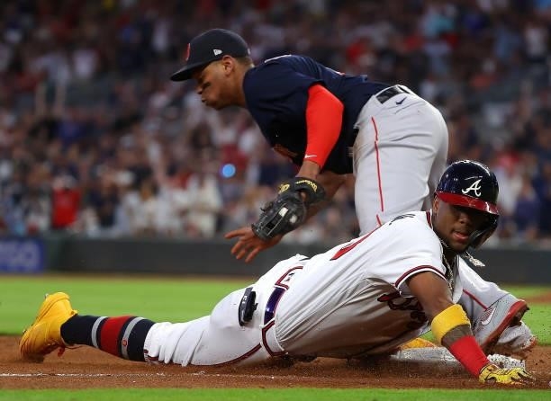 Ronald Acuna Jr. #13 of the Atlanta Braves dives safely into third base as he advances on a two-RBI double in the fourth inning under the tag of...