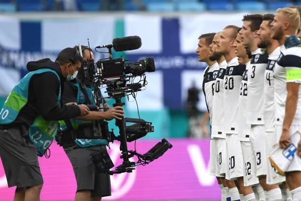 Players of Finland stand to sing the national anthem whilst being filmed by a 'steady cam' operator prior to the UEFA Euro 2020 Championship Group B...