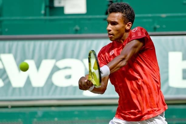 Felix Auger-Aliassime of Canada plays a backhand in his match against Roger Federer of Switzerland during day 5 of the Noventi Open at OWL-Arena on...