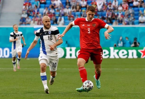 Igor Diveev of Russia passes the ball whilst under pressure from Teemu Pukki of Finland during the UEFA Euro 2020 Championship Group B match between...