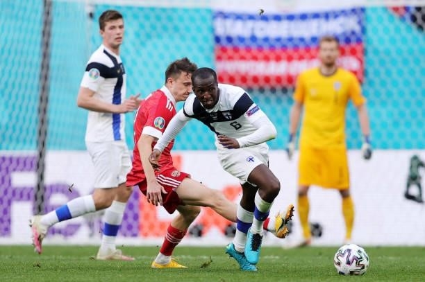 Glen Kamara of Finland is challenged by Magomed Ozdoev of Russia during the UEFA Euro 2020 Championship Group B match between Finland and Russia at...