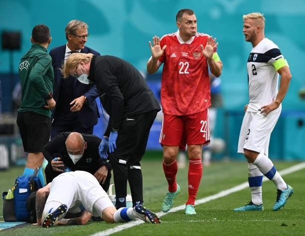 Joona Toivio of Finland receives medical treatment as Artem Dzyuba of Russia reacts behind as he speaks with Paulus Arajuuri of Finland during the...