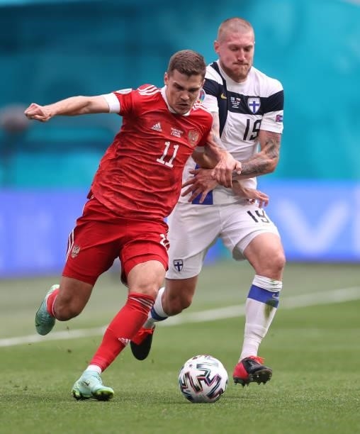 Roman Zobnin of Russia runs with the ball whilst under pressure from Joni Kauko of Finland during the UEFA Euro 2020 Championship Group B match...